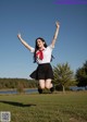 A woman in a school uniform jumping in the air.