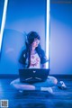 A woman sitting on the floor with a laptop computer.