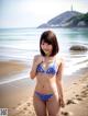 A woman in a bikini standing on a beach.