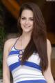 A woman in a blue and white striped dress posing for a picture.