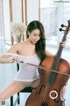 A woman sitting on a chair playing a cello.