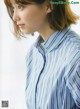 A woman wearing a blue and green striped shirt.