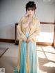 A woman in a blue and yellow hanfu is posing for a picture.