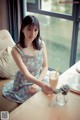 A woman sitting at a table with a glass of milk.