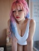 A woman with pink and blue hair posing for a picture.